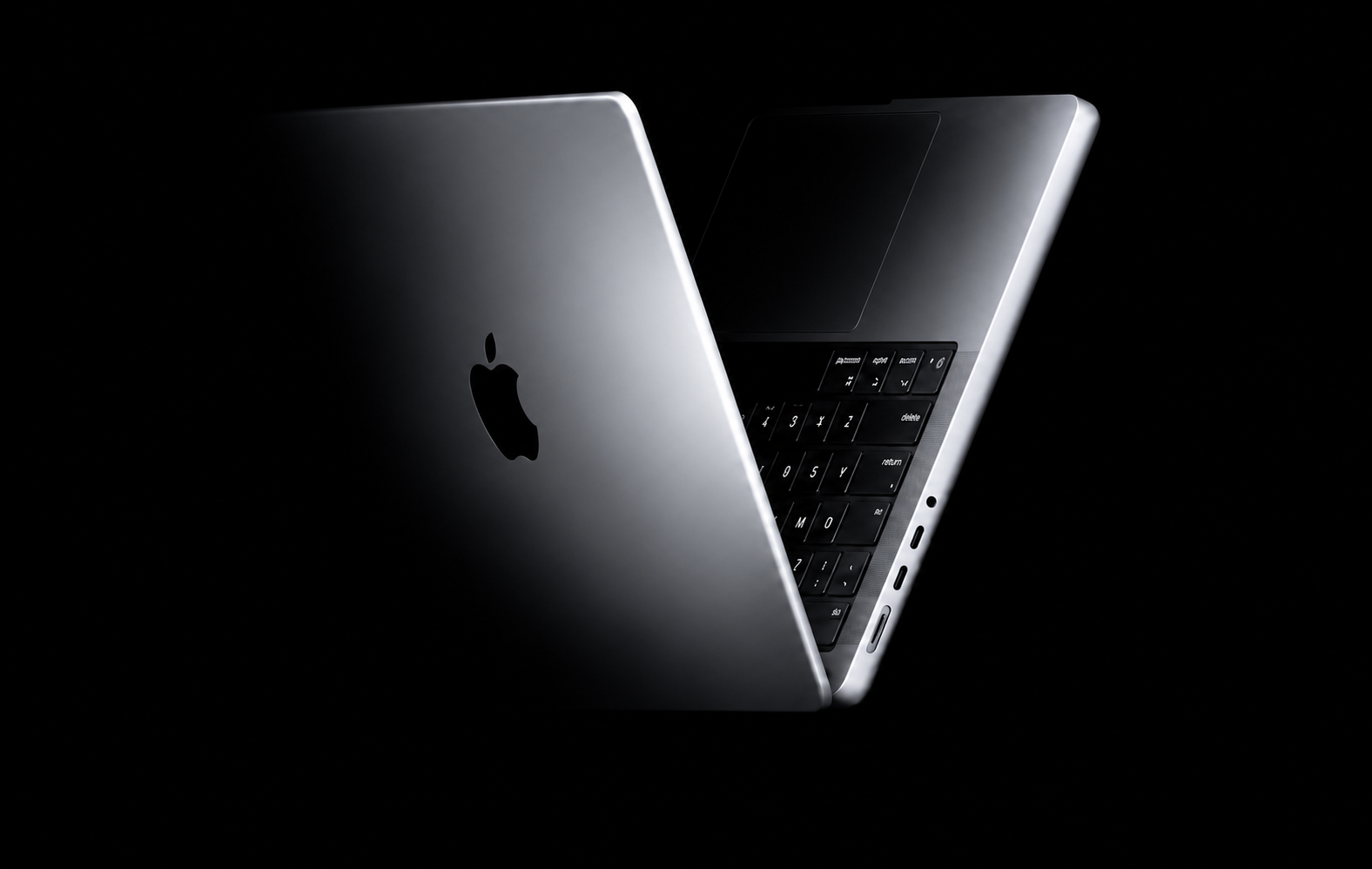 מחשב MacBook כסוף בצילום סטודיו על רקע שחור